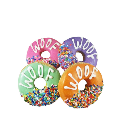 A selection of colorful dog-friendly 'dognuts' with icing and sprinkles, each topped with the word 'WOOF' in different colors.