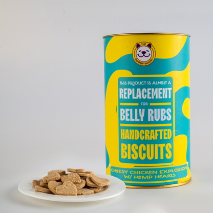 A canister labeled 'Doggy Bakery' with a colorful pattern, indicating it is a replacement product for belly rubs. In front of the canister, there are a few small, heart-shaped dog treats on a white plate.